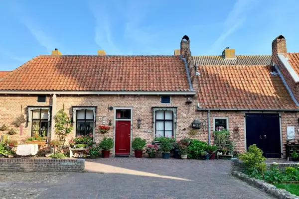 Rode klinkerbestrating op een binnenplaats voor oude bakstenen huisjes met pannendaken